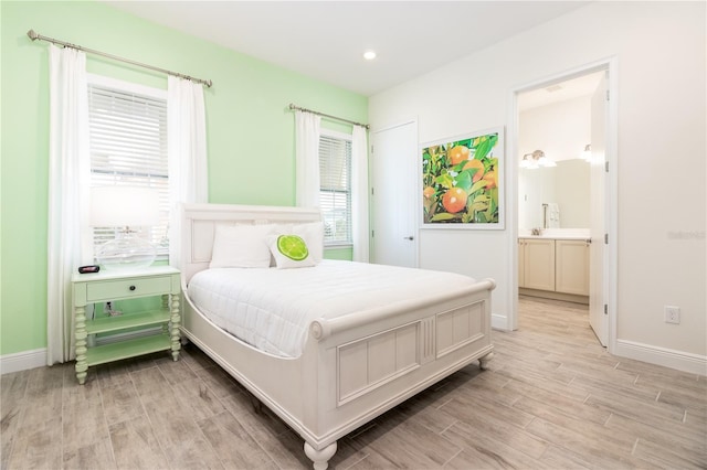 bedroom featuring light hardwood / wood-style floors and connected bathroom