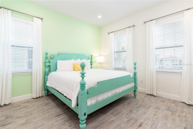 bedroom with multiple windows and light hardwood / wood-style floors