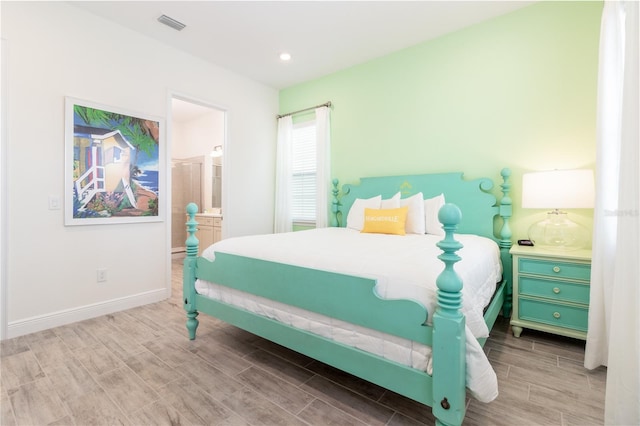 bedroom featuring connected bathroom and hardwood / wood-style floors