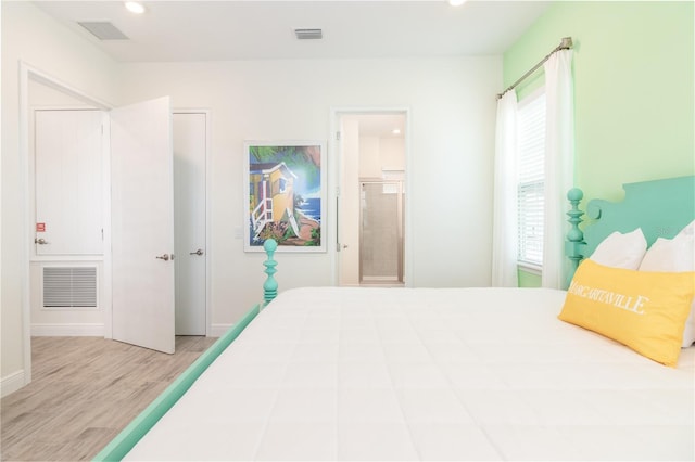 bedroom with light hardwood / wood-style floors and ensuite bath