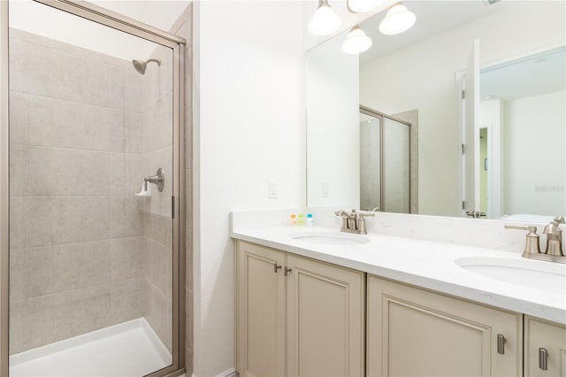 bathroom featuring large vanity, an enclosed shower, and double sink