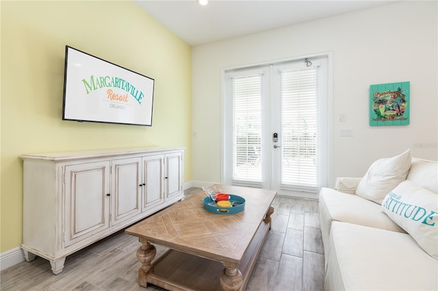 living room with a wealth of natural light, hardwood / wood-style floors, and french doors