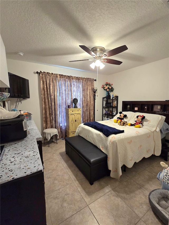 bedroom featuring tile flooring, ceiling fan, and a textured ceiling