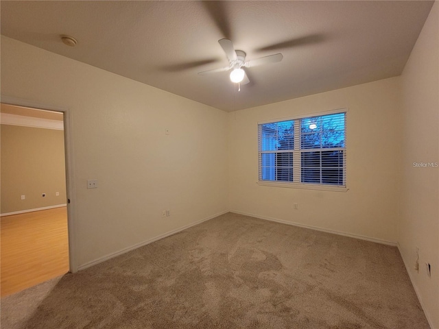 empty room with light colored carpet and ceiling fan