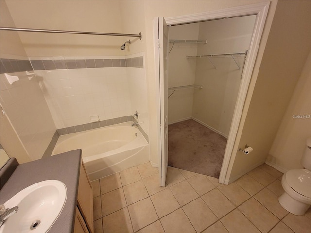 bathroom with tile patterned floors, toilet, sink, and a tub