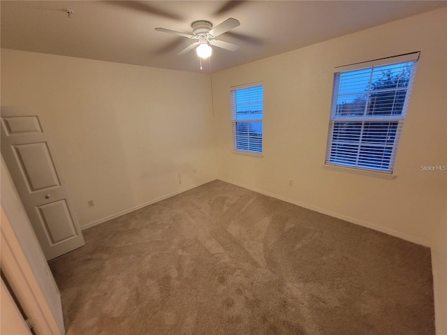 carpeted spare room with ceiling fan