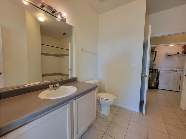 full bathroom with washtub / shower combination, vanity, separate washer and dryer, tile patterned flooring, and toilet