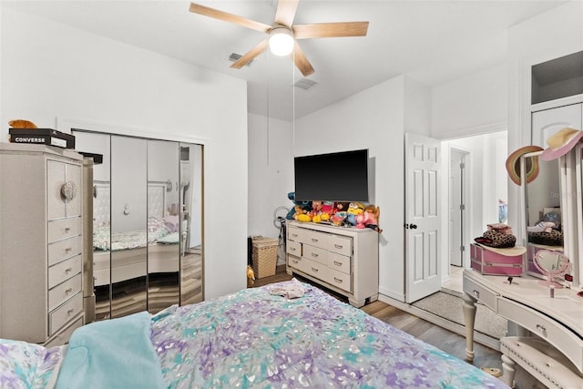 bedroom featuring ceiling fan, light hardwood / wood-style floors, and lofted ceiling