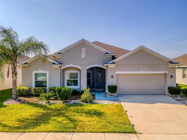 single story home featuring a garage and a front yard