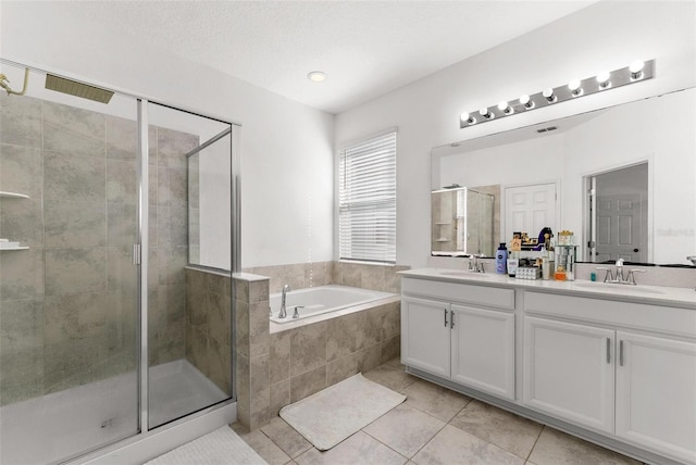 bathroom with oversized vanity, dual sinks, tile floors, and plus walk in shower