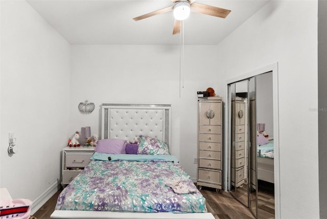 bedroom with dark hardwood / wood-style flooring, a closet, and ceiling fan