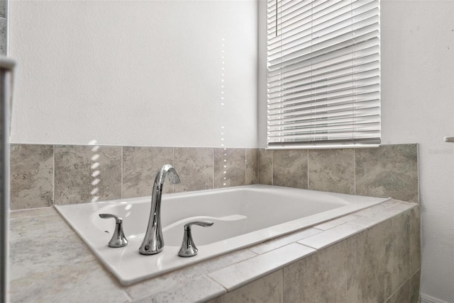 bathroom featuring tiled tub and plenty of natural light