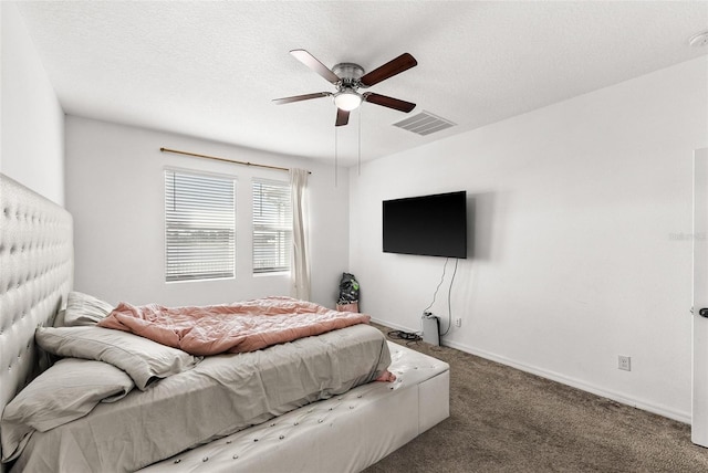 carpeted bedroom featuring ceiling fan and a textured ceiling