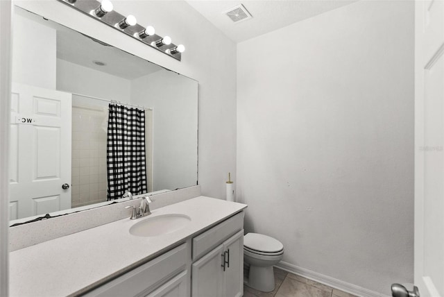 bathroom with tile floors, vanity with extensive cabinet space, and toilet