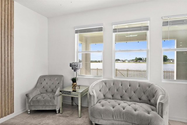 living area featuring a water view and light tile floors