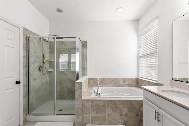 bathroom featuring vanity with extensive cabinet space, a textured ceiling, and plus walk in shower