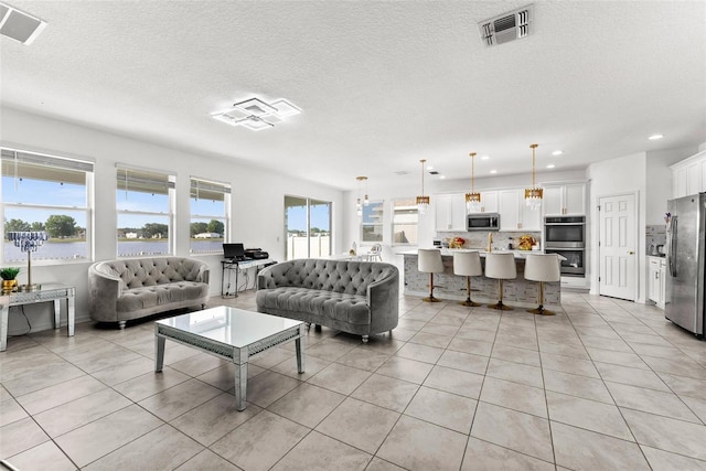 tiled living room featuring a notable chandelier and a textured ceiling