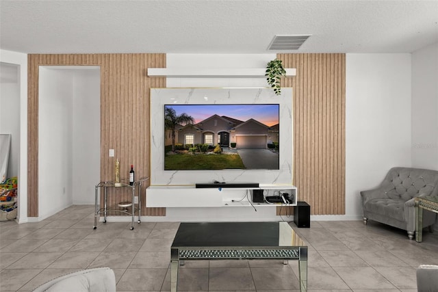 living room with a textured ceiling and light tile floors