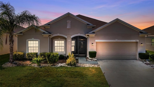 view of front of house featuring a garage and a lawn