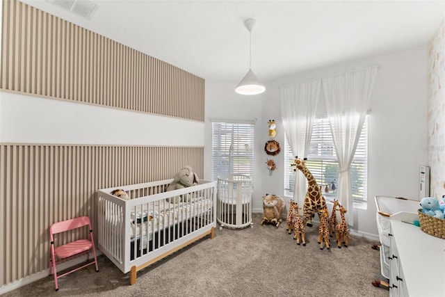 carpeted bedroom featuring a nursery area