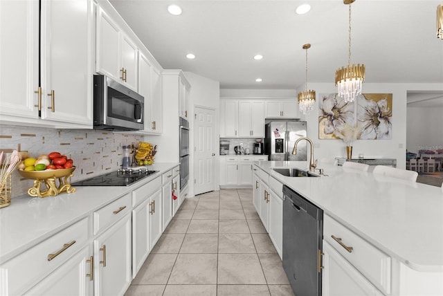 kitchen featuring appliances with stainless steel finishes, white cabinets, sink, and tasteful backsplash