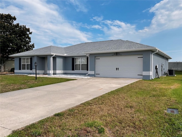 ranch-style house featuring a garage, a front lawn, and central AC unit