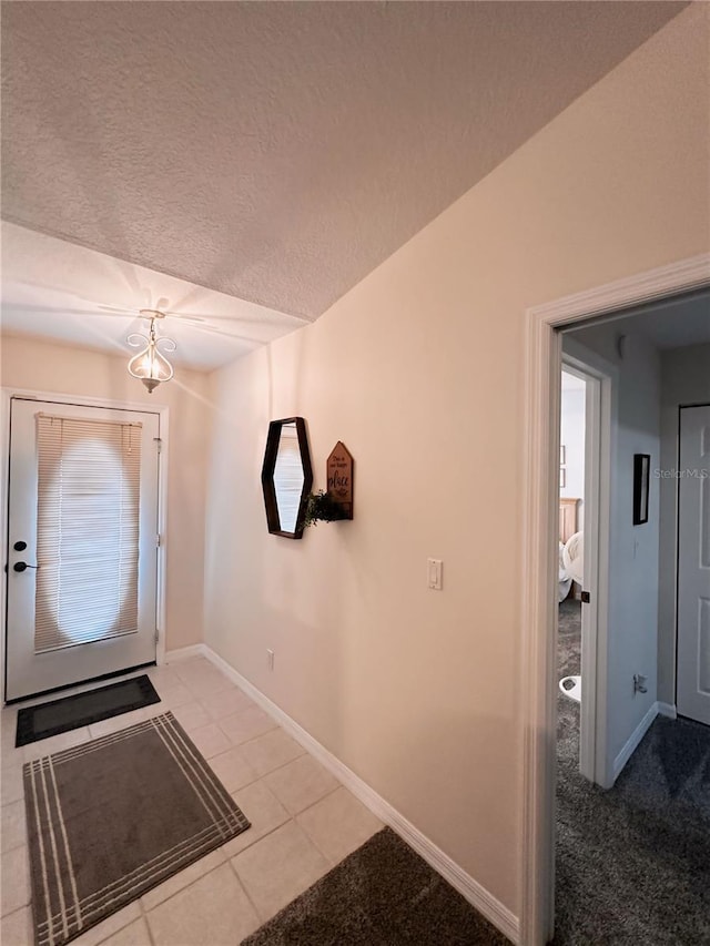 foyer with a textured ceiling and carpet flooring