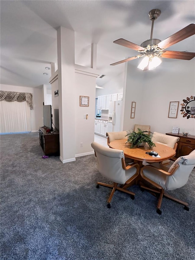 carpeted dining space featuring vaulted ceiling and ceiling fan