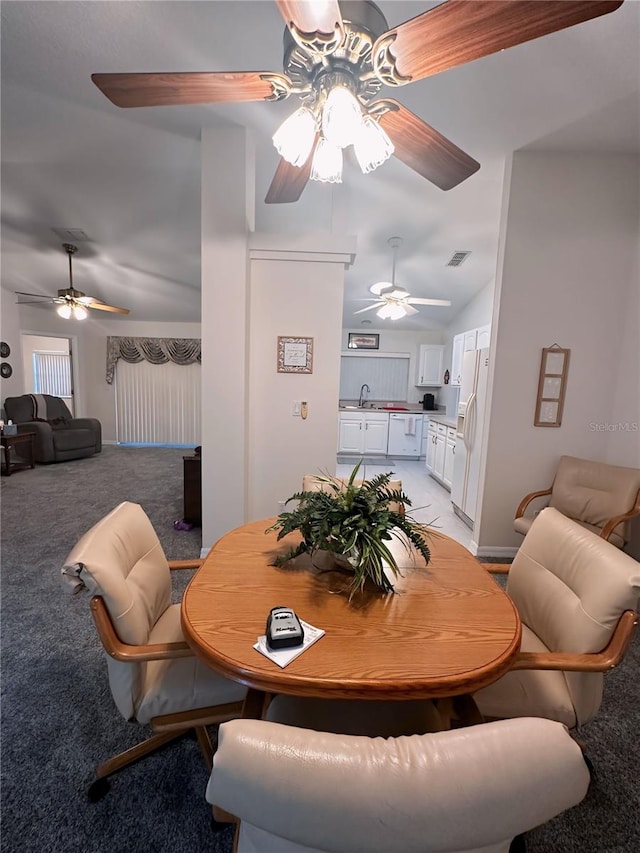 dining space with ceiling fan, light colored carpet, sink, and lofted ceiling