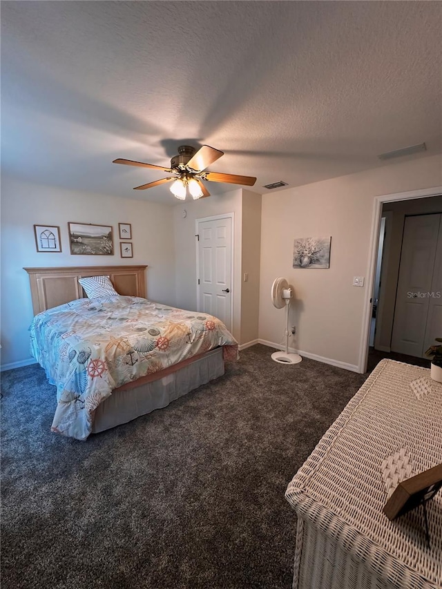 bedroom featuring a textured ceiling, dark colored carpet, and ceiling fan