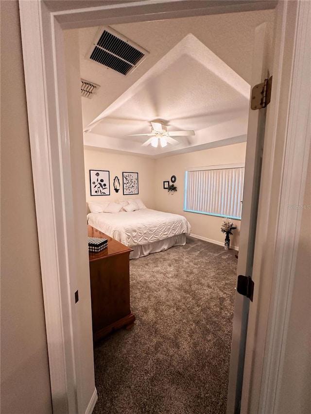 carpeted bedroom featuring ceiling fan and a textured ceiling