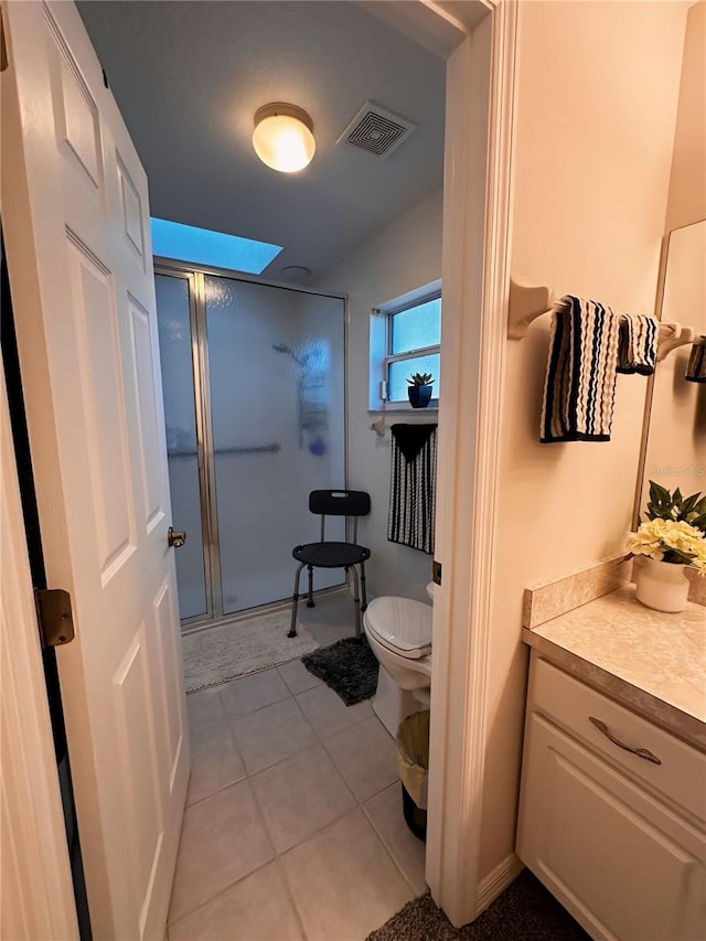 bathroom with tile floors, walk in shower, vanity, and toilet