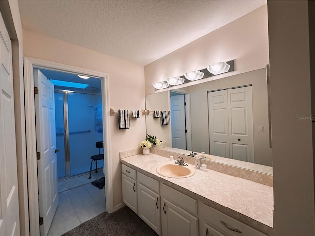 bathroom with tile floors, a textured ceiling, and large vanity