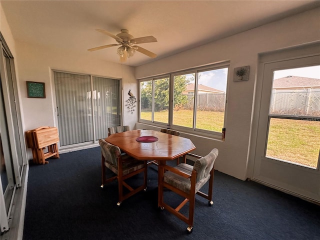 dining room featuring ceiling fan and dark colored carpet