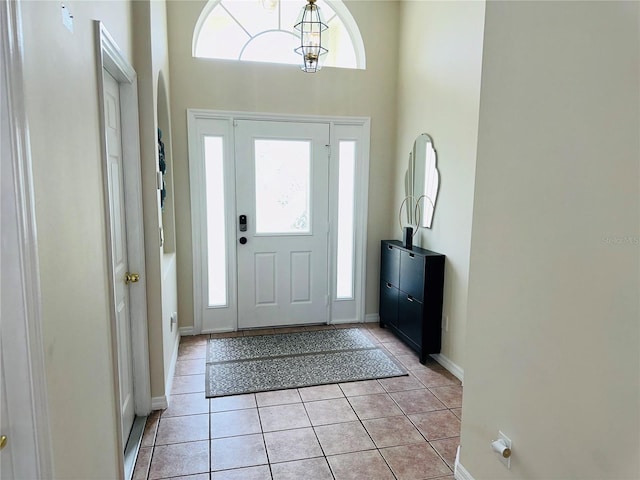 foyer entrance featuring a towering ceiling and light tile patterned floors