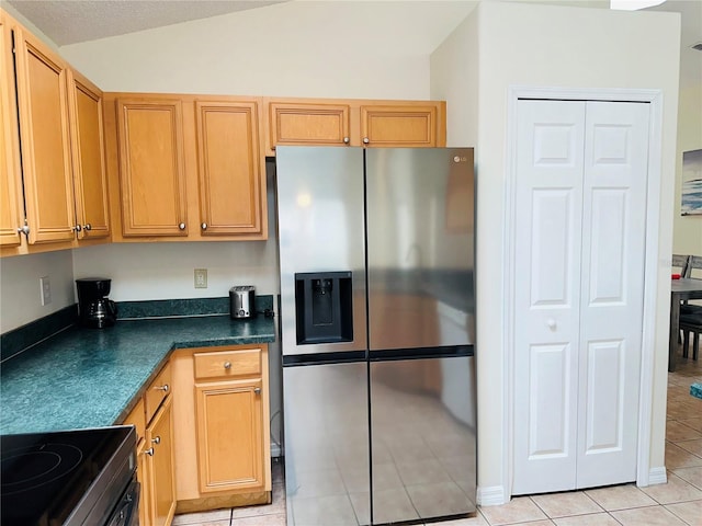 kitchen with light tile patterned flooring, range, vaulted ceiling, and stainless steel fridge with ice dispenser