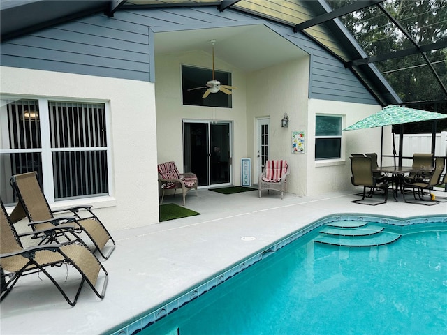 rear view of property featuring glass enclosure, a patio area, and ceiling fan