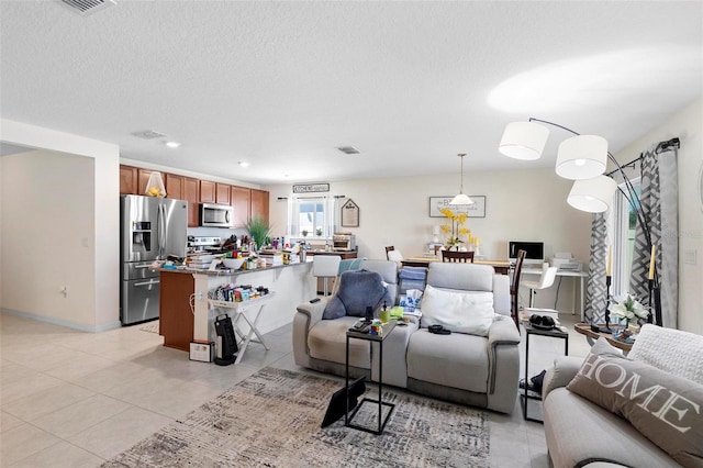 living room featuring a textured ceiling and light tile floors