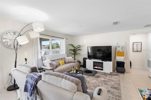 living room with a textured ceiling and light tile flooring