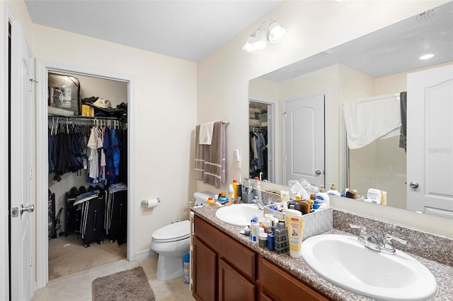 bathroom with double vanity, walk in shower, toilet, and tile floors