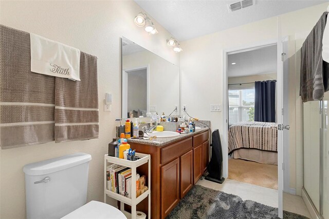 bathroom featuring vanity with extensive cabinet space, an enclosed shower, and toilet