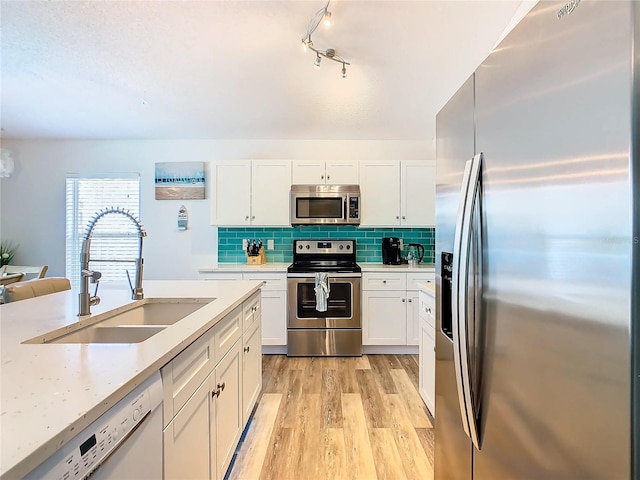 kitchen featuring white cabinetry, stainless steel appliances, light hardwood / wood-style floors, and sink