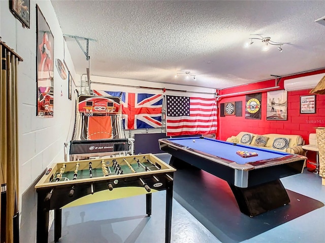 playroom featuring a textured ceiling, a wall mounted air conditioner, concrete flooring, and pool table