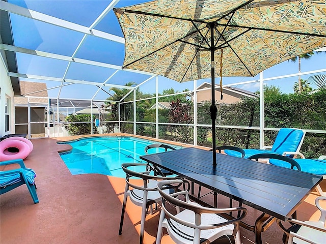 view of swimming pool featuring glass enclosure and a patio