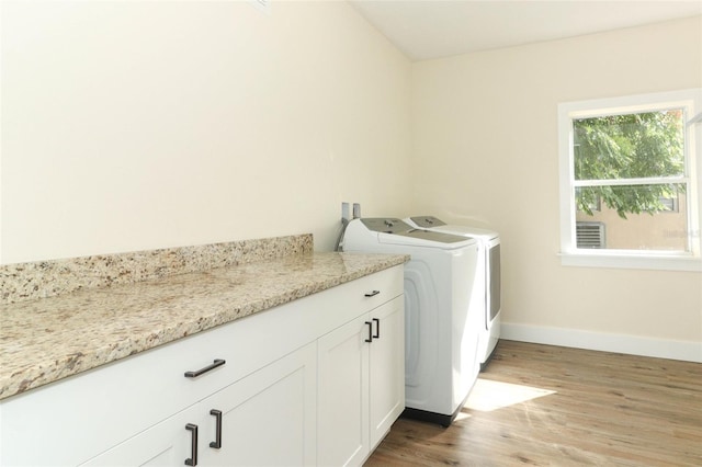 washroom featuring light wood-type flooring, cabinets, and independent washer and dryer