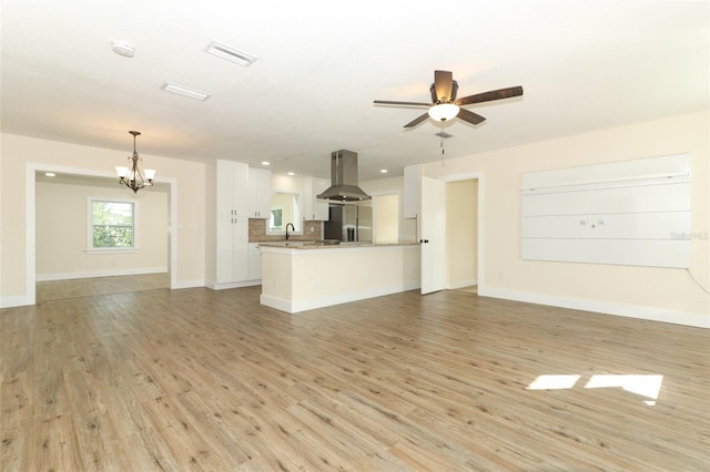 unfurnished living room with sink, light hardwood / wood-style floors, and ceiling fan with notable chandelier