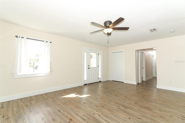 empty room featuring ceiling fan, hardwood / wood-style floors, and a healthy amount of sunlight