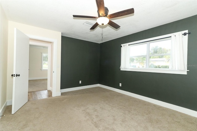 spare room with light colored carpet and ceiling fan