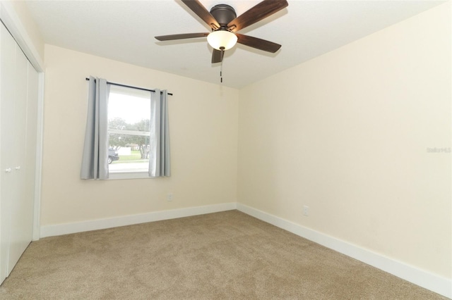 empty room with light colored carpet and ceiling fan