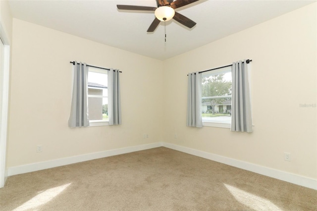 unfurnished room featuring light colored carpet and ceiling fan